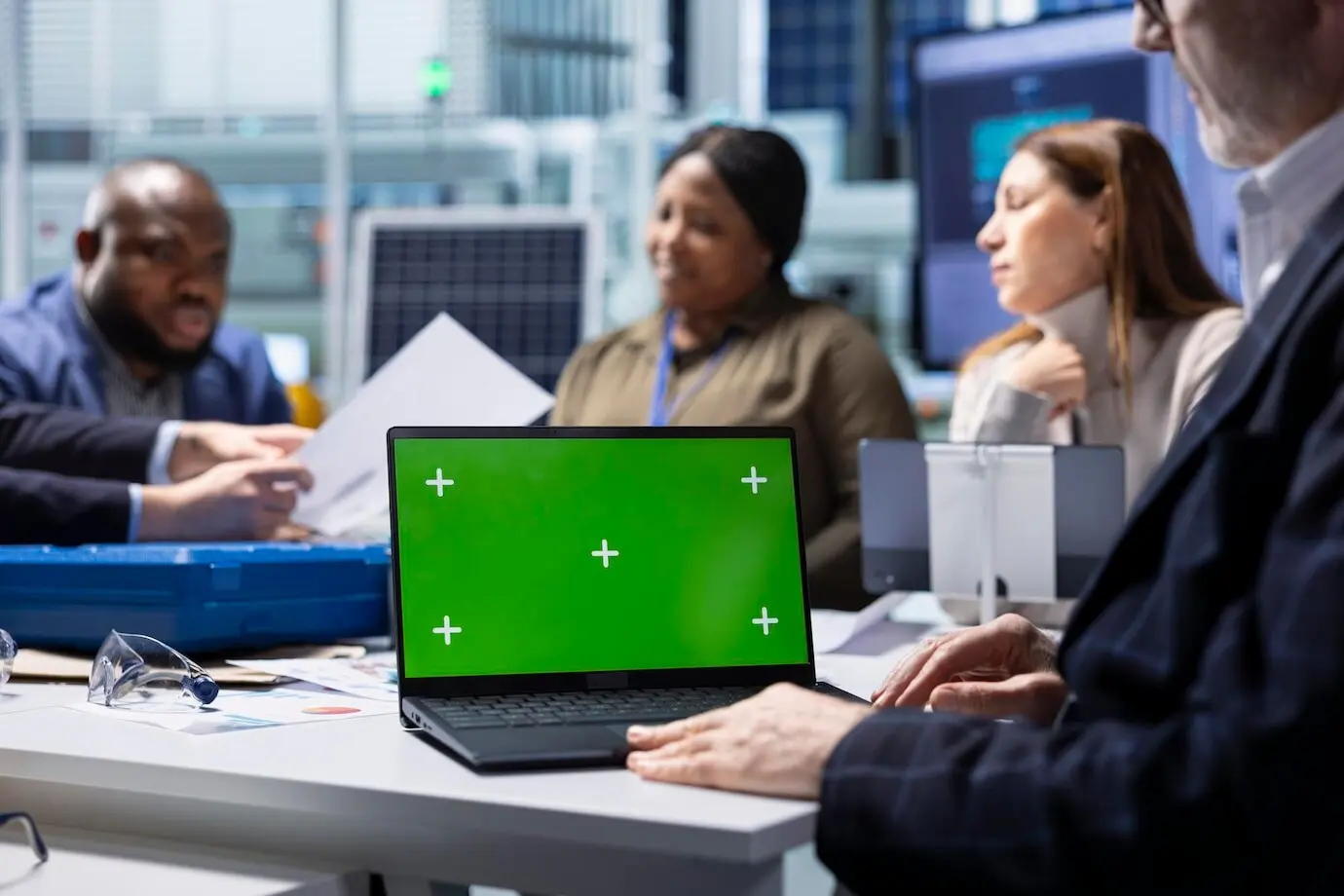 Инвесторы фабрики изучают документацию на макете ноутбука.